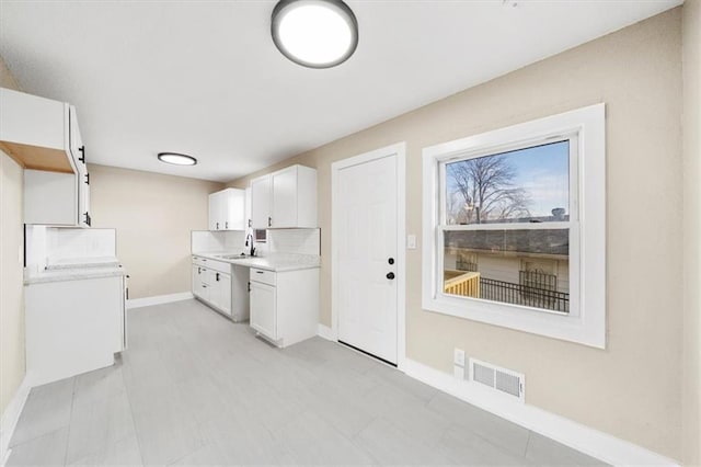 kitchen with white cabinets and decorative backsplash