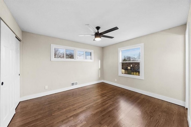 unfurnished bedroom with dark wood-type flooring, ceiling fan, and a closet