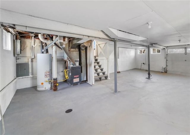 basement with heating unit, a healthy amount of sunlight, and water heater