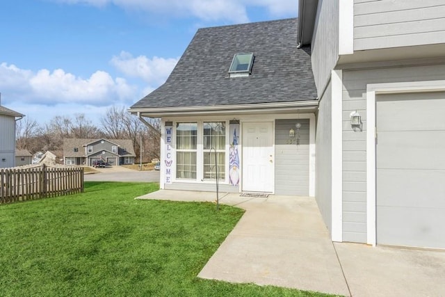 entrance to property with a garage and a lawn