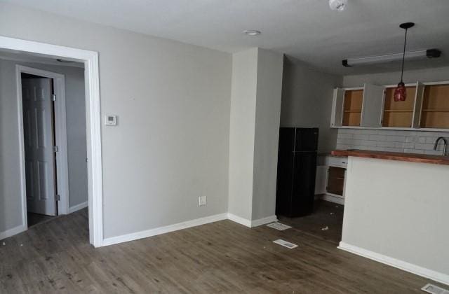 kitchen with dark hardwood / wood-style floors, wooden counters, decorative light fixtures, and tasteful backsplash