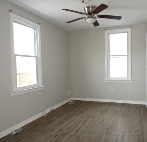 empty room with dark wood-type flooring and ceiling fan