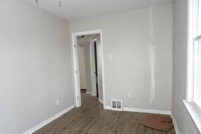 unfurnished room with dark hardwood / wood-style flooring