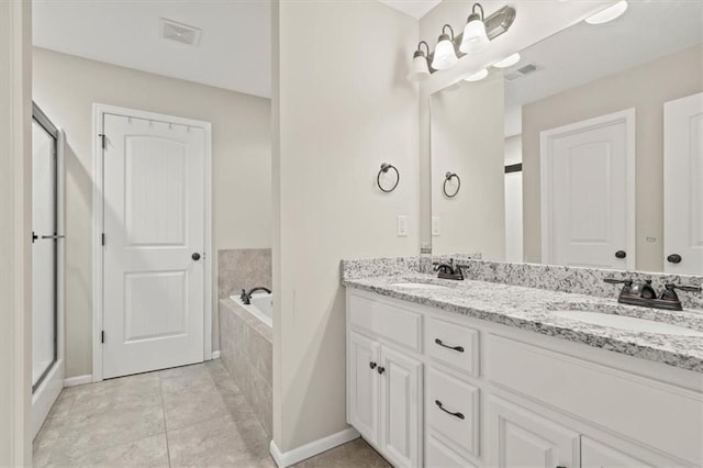 bathroom featuring vanity, tile patterned flooring, and tiled bath