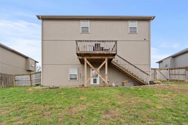 back of house with a wooden deck, central AC, and a lawn