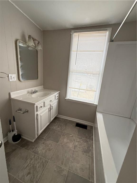 full bathroom with visible vents, vanity, and baseboards