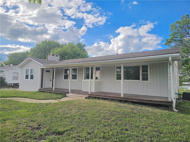 623 E Monroe Ave, Garnett, KS 66032 - view of front facade featuring covered porch, cooling unit, a chimney, and a front yard