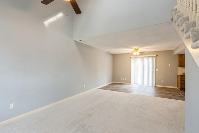 unfurnished living room featuring ceiling fan and carpet floors