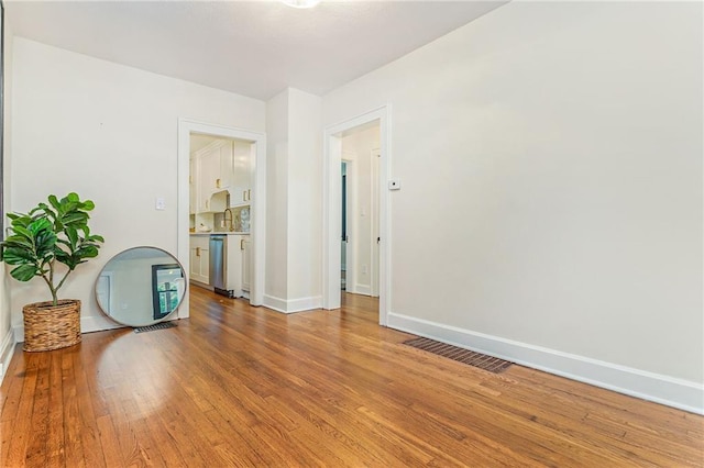 spare room featuring wood-type flooring and sink