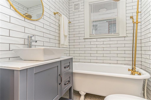 bathroom with vanity, tile walls, and a tub to relax in