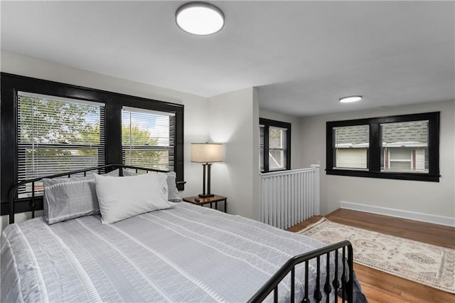 bedroom with hardwood / wood-style floors and multiple windows