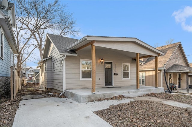 bungalow with covered porch and a patio area