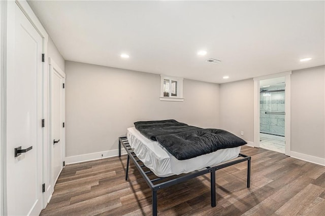 bedroom featuring dark hardwood / wood-style flooring and ensuite bath