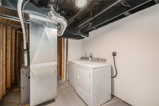 clothes washing area with washer and clothes dryer and heating unit