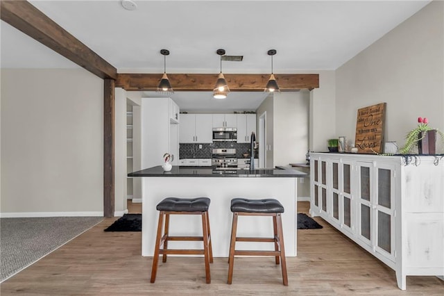 kitchen featuring decorative light fixtures, tasteful backsplash, beamed ceiling, white cabinets, and stainless steel appliances