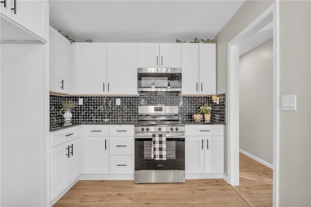 kitchen featuring white cabinetry, stainless steel appliances, decorative backsplash, and light wood-type flooring