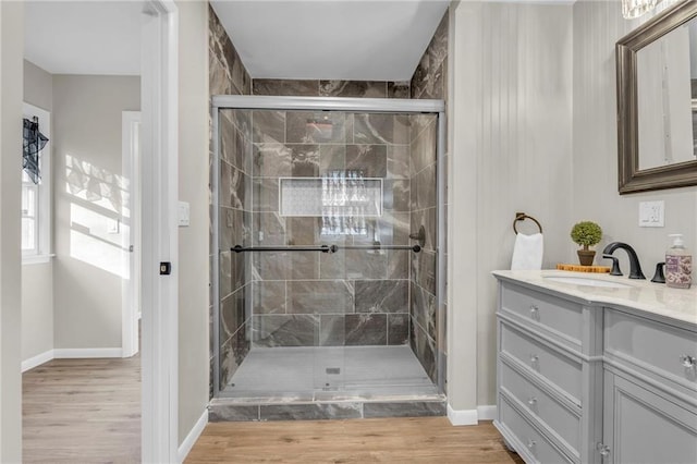 bathroom featuring hardwood / wood-style flooring, vanity, and walk in shower