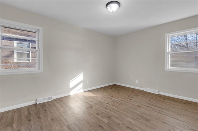 unfurnished room with hardwood / wood-style flooring