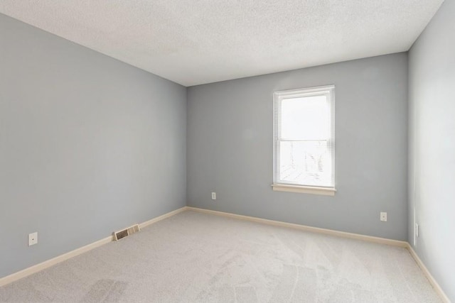 carpeted spare room with a textured ceiling