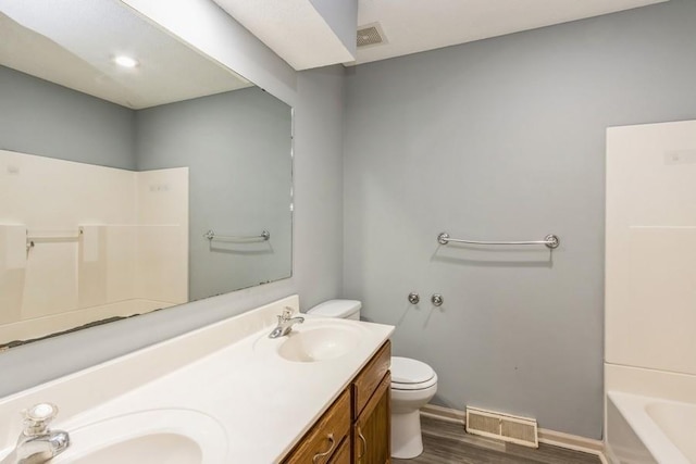 bathroom featuring vanity, hardwood / wood-style floors, and toilet