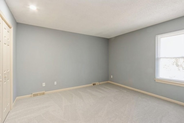 spare room with carpet floors and a textured ceiling