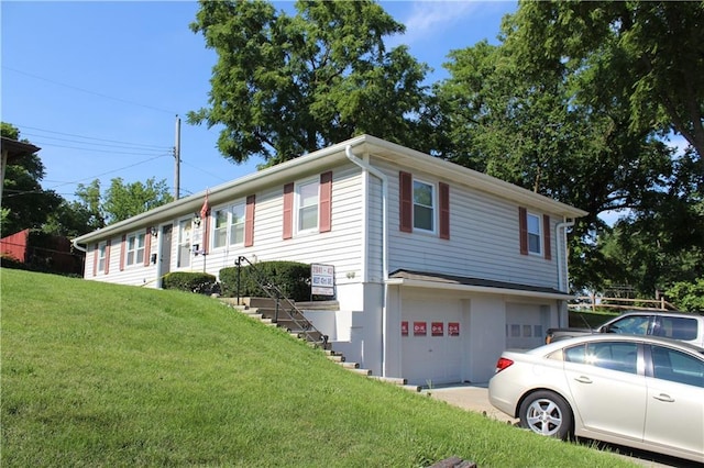 view of front facade featuring a front yard, driveway, stairway, and an attached garage