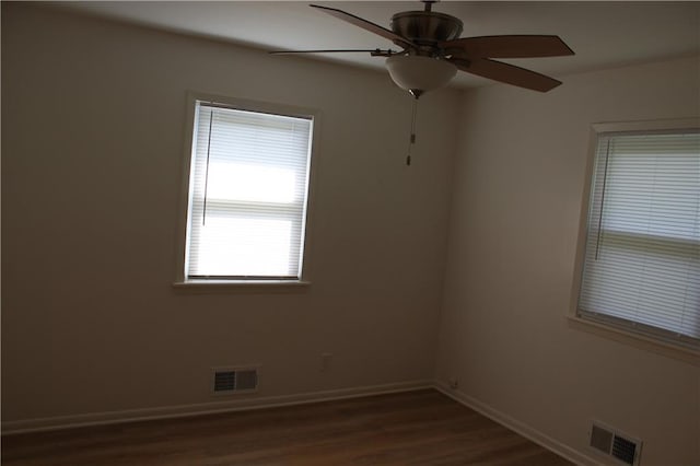 unfurnished room with dark wood finished floors, baseboards, and visible vents