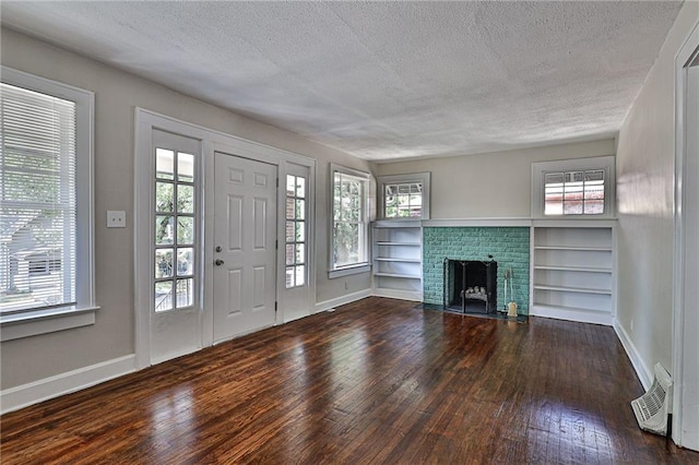 entrance foyer with dark wood-type flooring, a textured ceiling, and a fireplace