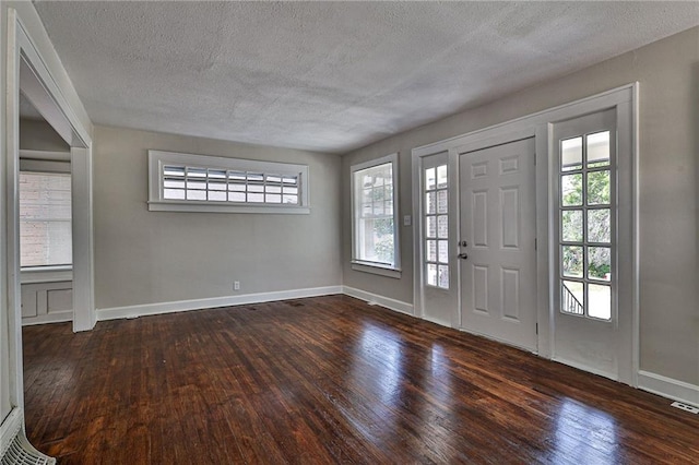 entrance foyer with dark hardwood / wood-style floors and a textured ceiling