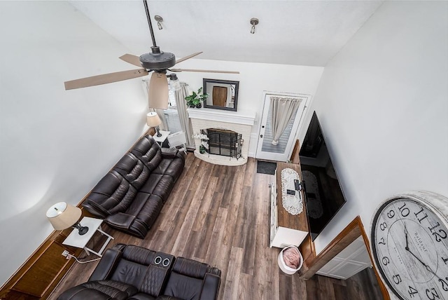 living room with a fireplace, ceiling fan, and wood-type flooring