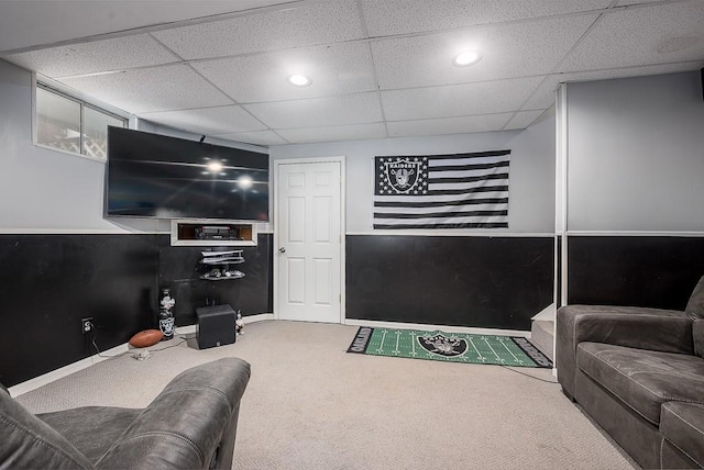 living room with a drop ceiling and carpet flooring