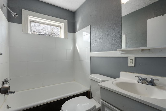 full bathroom featuring tiled shower / bath, vanity, and toilet