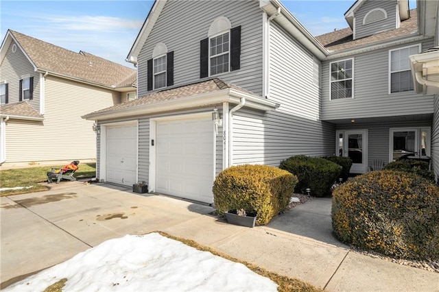 view of side of property featuring an attached garage and concrete driveway