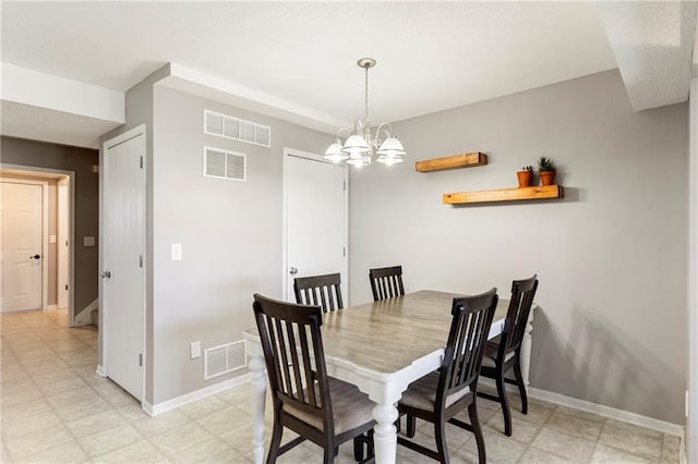 dining area featuring visible vents, a notable chandelier, and baseboards