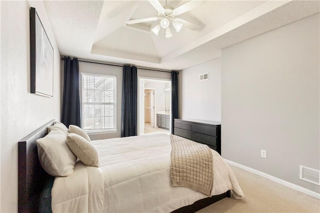 carpeted bedroom with ceiling fan, baseboards, visible vents, and a raised ceiling