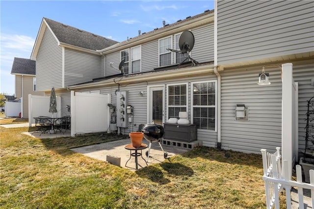 back of property with a yard, a patio area, and fence