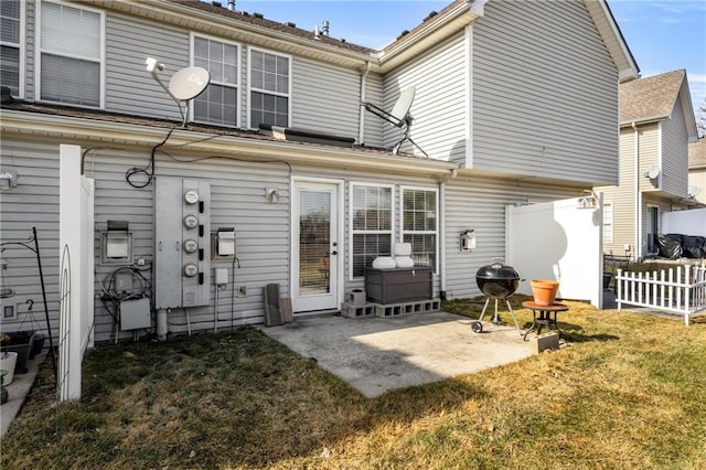 back of property with a patio, a lawn, and fence