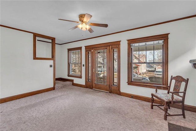 unfurnished room featuring ceiling fan, ornamental molding, light carpet, and a wealth of natural light