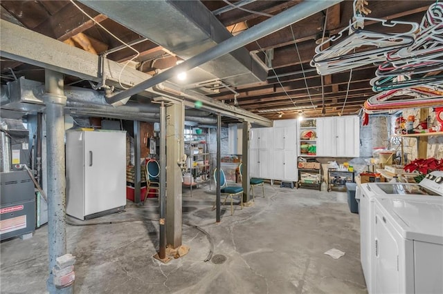 basement featuring washer and clothes dryer and white refrigerator