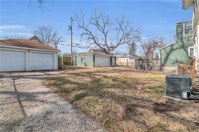 view of yard featuring a garage, an outdoor structure, and central air condition unit