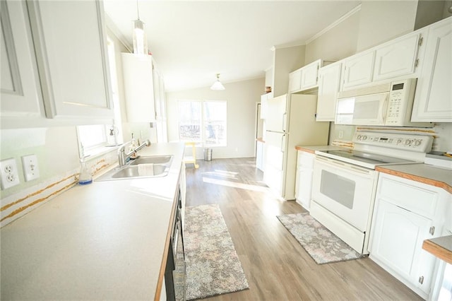 kitchen with pendant lighting, sink, white appliances, white cabinets, and light wood-type flooring