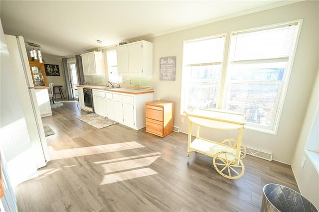 kitchen featuring dishwasher, white cabinets, white refrigerator, crown molding, and light hardwood / wood-style flooring