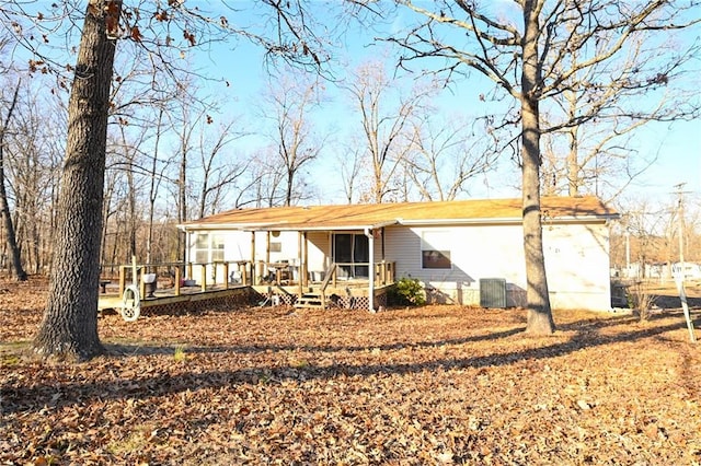 rear view of property with cooling unit and a deck