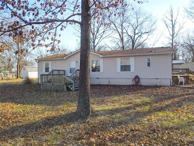 rear view of house featuring a wooden deck