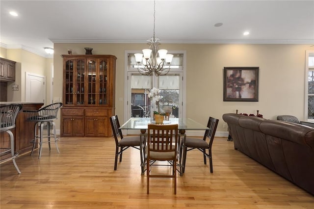 dining space with a chandelier, ornamental molding, light wood-style flooring, and recessed lighting