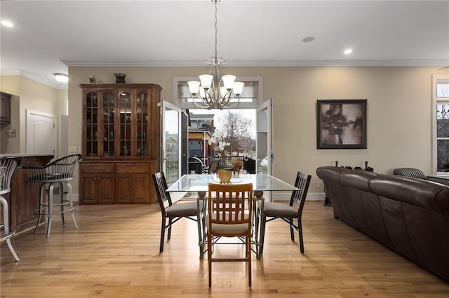 dining room featuring light wood-style flooring, recessed lighting, baseboards, an inviting chandelier, and crown molding