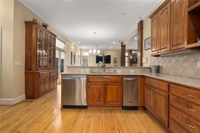 kitchen featuring decorative backsplash, light stone countertops, crown molding, stainless steel dishwasher, and a sink