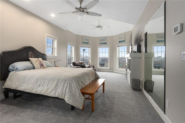 bedroom featuring carpet floors, multiple windows, baseboards, and vaulted ceiling