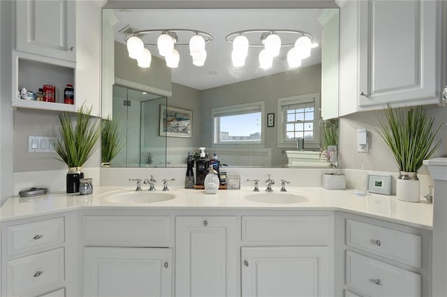 full bath with a sink, a shower stall, and double vanity