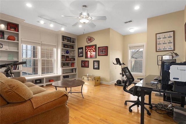 office with baseboards, wood finished floors, visible vents, and a ceiling fan